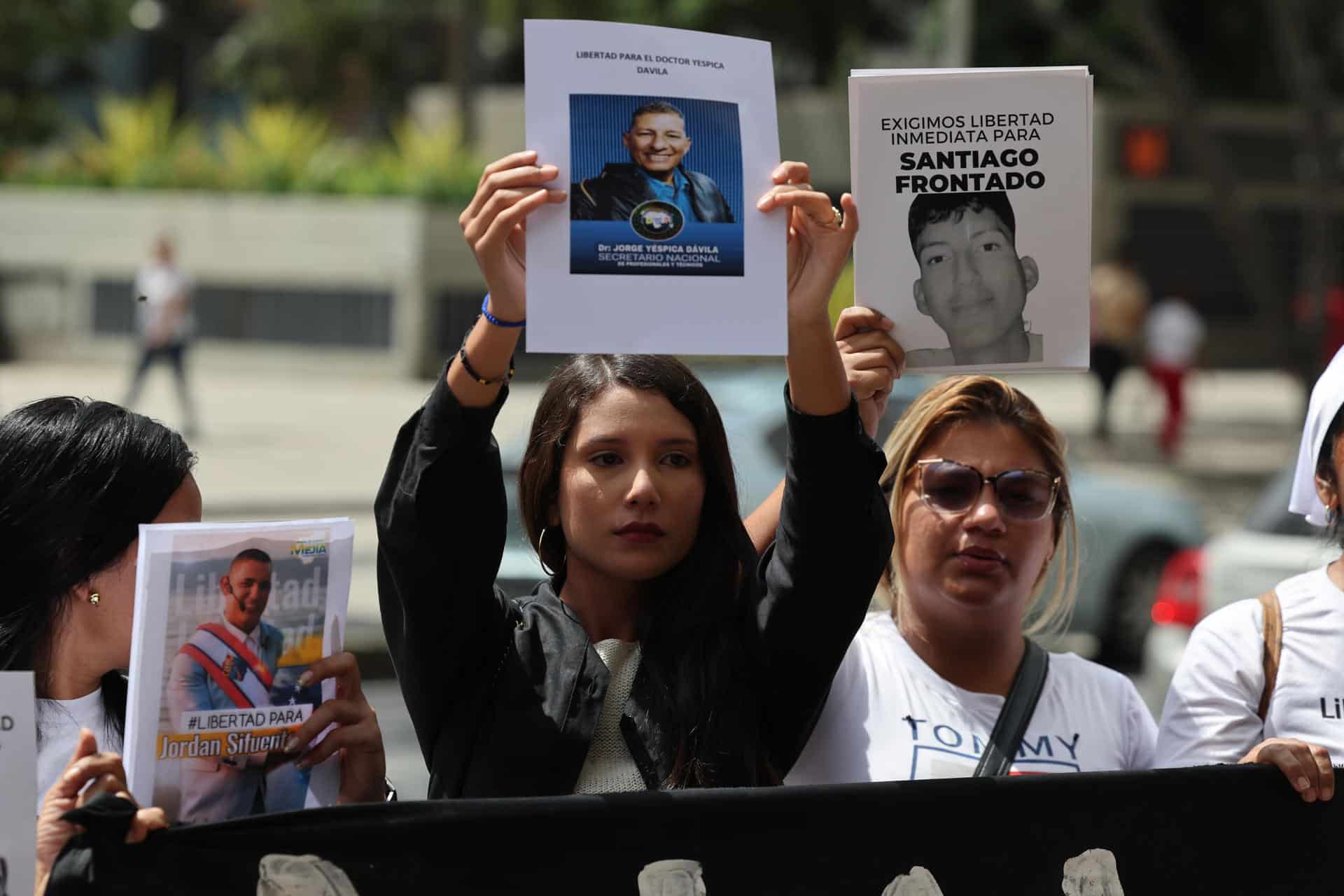 Familiares de detenidos sostienen retratos este jueves, afuera de la sede del Ministerio Público en Caracas (Venezuela). EFE/ Miguel Gutiérrez