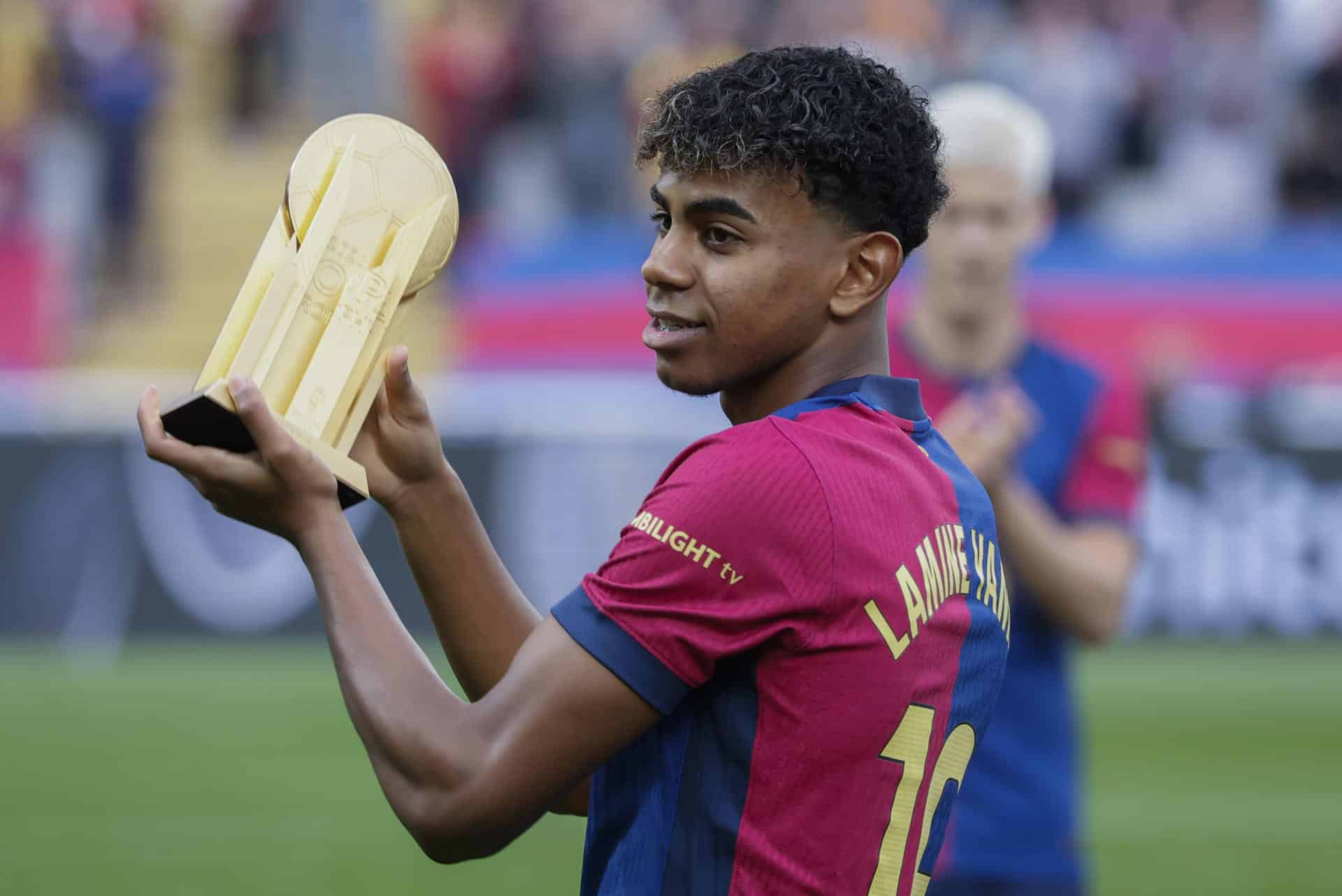 El extremo del FC Barcelona Lamine Yamal posa con el Trofeo Kopa, que designa al mejor futbolista del mundo menor de 21 años y que recibió en la gala del Balón de Oro 2024, antes del partido de LaLiga que enfrenta al FC Barcelona contra el Espanyol este domingo en el Camp Nou en Barcelona. EFE/ Andreu Dalmau