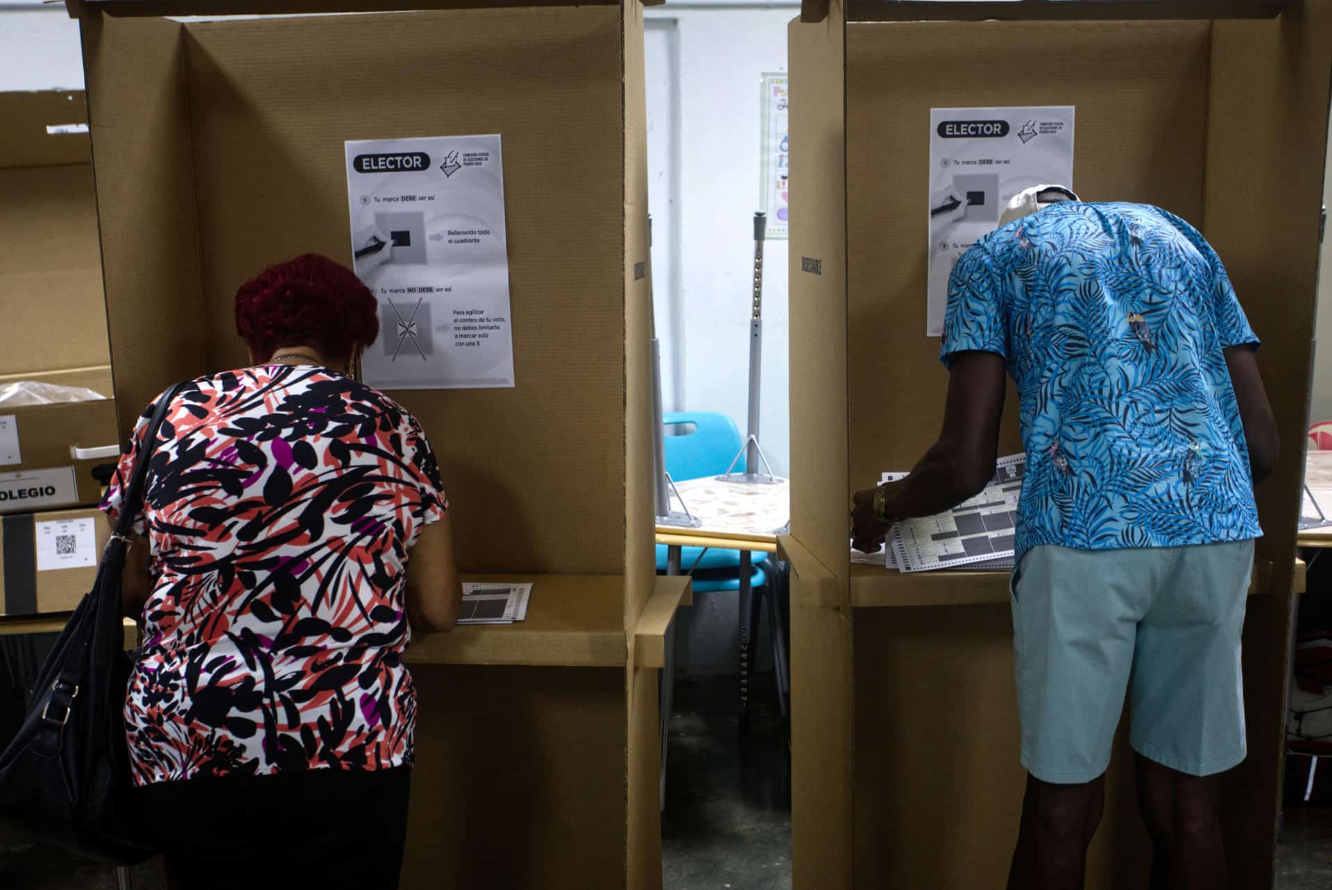 Dos personas marcan sus papeletas electorales este martes en un centro de votación en Carolina (Puerto Rico). EFE/Thais Llorca