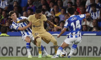 El delantero del FC Barcelona Raphinha (c) trata de controlar un balón ante Take Kubo (d), de la Real Sociedad, durante el partido de Liga de la pasada temporada disputado en el Reale Arena, en San Sebastián. EFE/Javier Etxezarreta