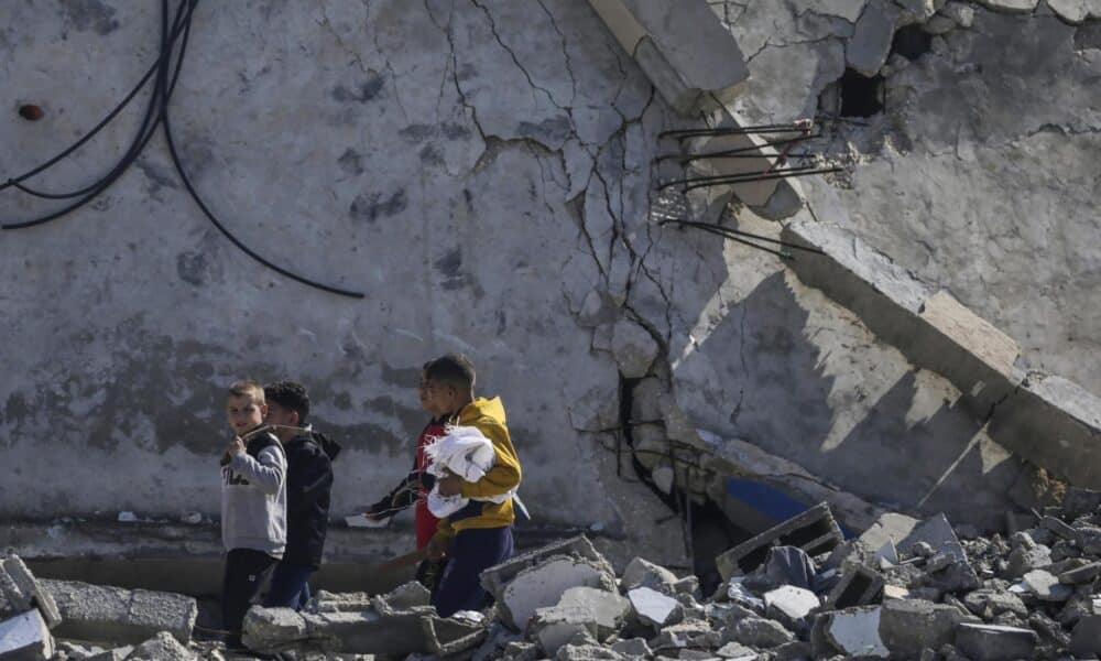 En la imagen de archivo, niños palestinos caminan junto a su casa destruida tras un ataque aéreo israelí contra el campo de refugiados de Al Maghazi, en el sur de la Franja de Gaza. EFE/EPA/MOHAMMED SABLE