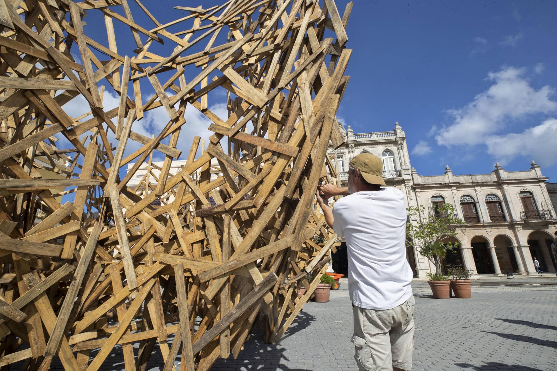 El artista alemán Martin Steinert trabaja en su obra "Nube de madera", este viernes en una plaza de La Habana (CUBA). Con unos ocho metros de alto y casi diez de diámetro, la escultura efímera "Nube de madera" busca desde este viernes el diálogo y la interacción con los cubanos desde su emplazamiento en una de las plazas históricas de La Habana Vieja. EFE/ Yander Zamora