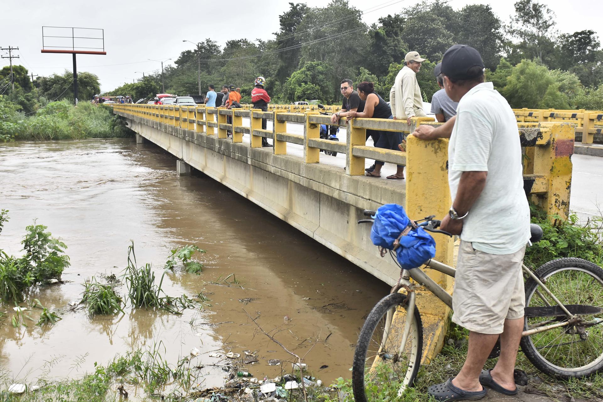 Pobladores observan el aumento del caudal del rio Chamelecón luego de que el gobierna emitiera alerta roja. Imagen de archivo. EFE/José Valle