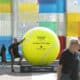 -Una persona se fotografía junto a una de la pelotas de tenis gigantes que se han instalado por el centro de la ciudad dentro de los preparativos para la celebración de las finales de la Copa Billie Jean King, en una foto de archivo. EFE/Daniel Pérez