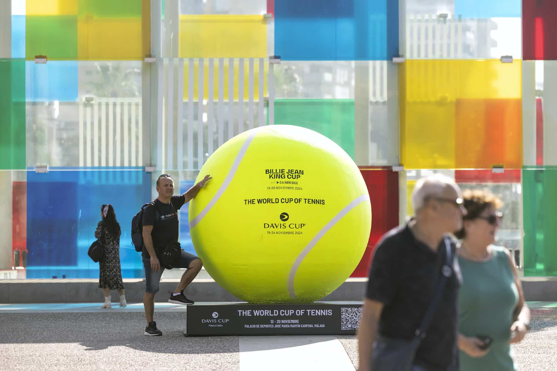 -Una persona se fotografía junto a una de la pelotas de tenis gigantes que se han instalado por el centro de la ciudad dentro de los preparativos para la celebración de las finales de la Copa Billie Jean King, en una foto de archivo. EFE/Daniel Pérez