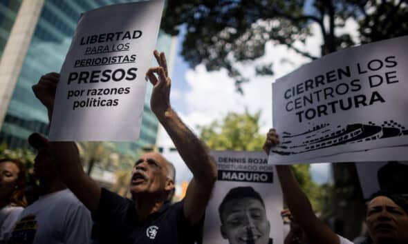 Fotografía de archivo del pasado 18 de octubre de personas que sostienen carteles con imágenes de detenidos  considerados presos políticos durante una manifestación frente a la sede del Ministerio de Servicio Penitenciario, en Caracas (Venezuela). EFE/ Miguel Gutierrez