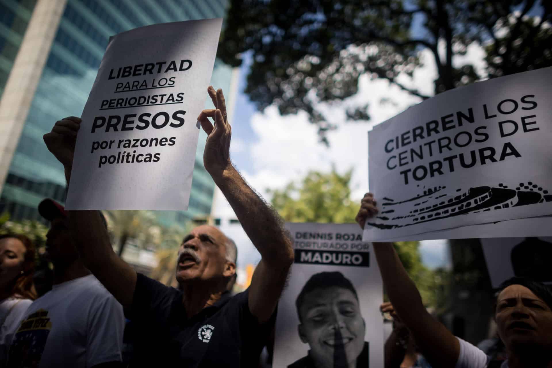 Fotografía de archivo del pasado 18 de octubre de personas que sostienen carteles con imágenes de detenidos  considerados presos políticos durante una manifestación frente a la sede del Ministerio de Servicio Penitenciario, en Caracas (Venezuela). EFE/ Miguel Gutierrez