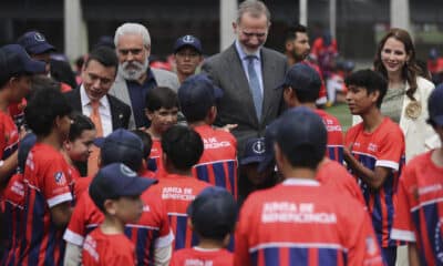 El rey Felipe VI saluda a niños en la inauguración de una nueva escuela del Atlético de Madrid en Cuenca (Ecuador). EFE/ José Jácome