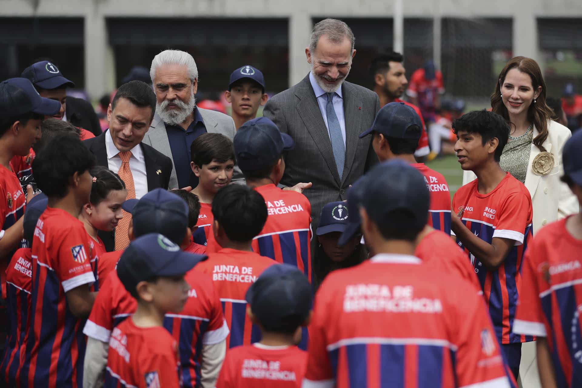 El rey Felipe VI saluda a niños en la inauguración de una nueva escuela del Atlético de Madrid en Cuenca (Ecuador). EFE/ José Jácome