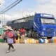 Una mujer Quechua camina delante de personas que hacen filas para comprar combustible en una estación de servicio este jueves en Cochabamba (Bolivia). EFE/Jorge Abrego