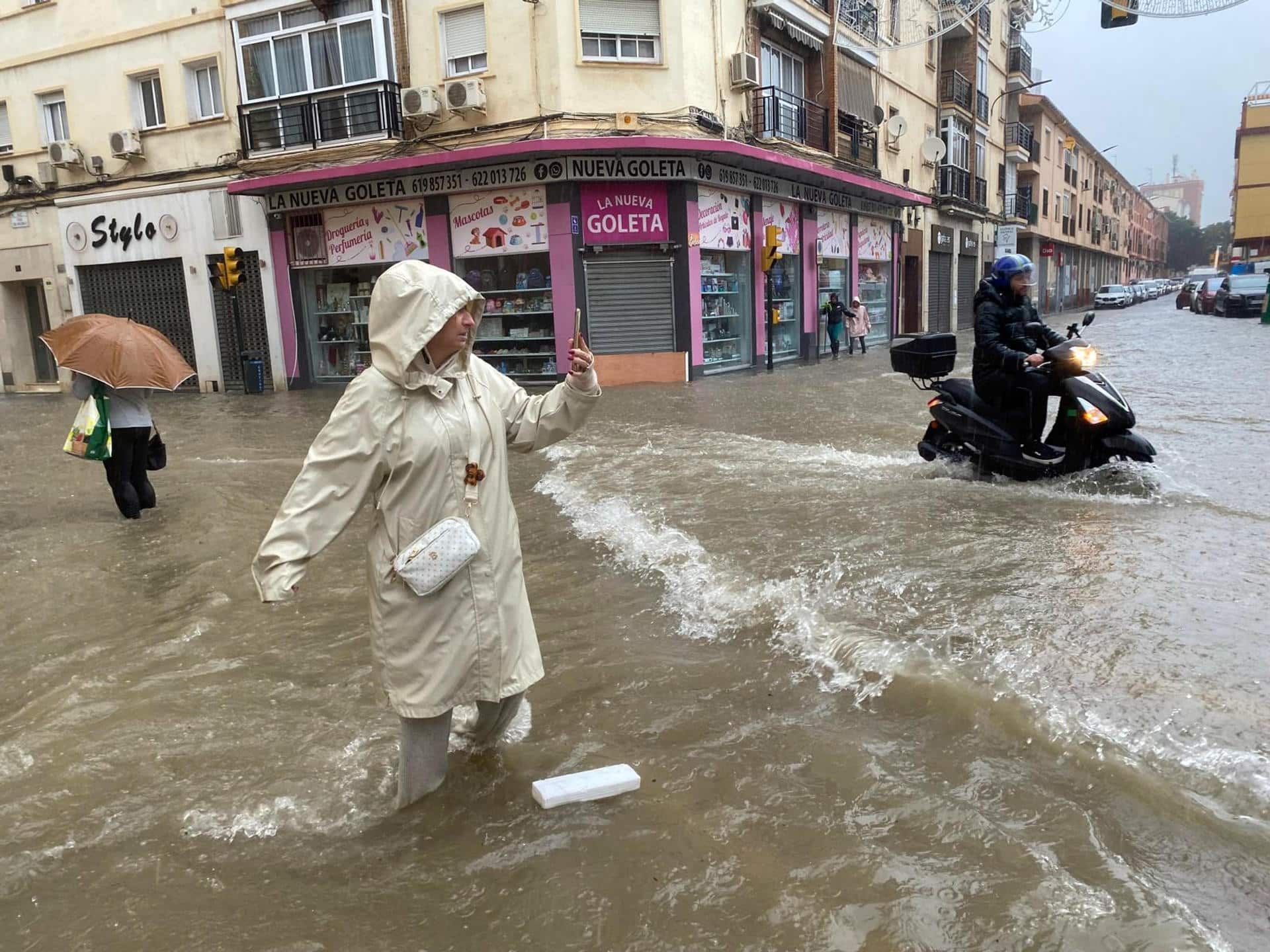 Una mujer hace fotos en Málaga durante las inundaciones sucedidas en el sur de España. EFE/María Alonso