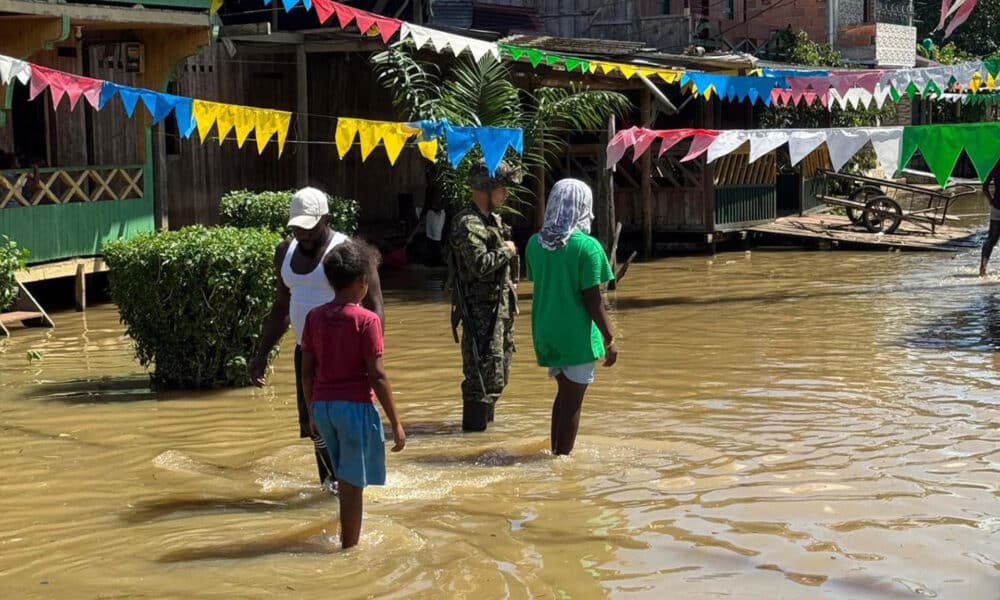 Fotografía cedida por el Ejército de Colombia que muestra un soldado con tres personas en una calle inundada en Alto Baudó (Colombia). EFE/Ejército de Colombia