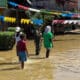 Fotografía cedida por el Ejército de Colombia que muestra un soldado con tres personas en una calle inundada en Alto Baudó (Colombia). EFE/Ejército de Colombia