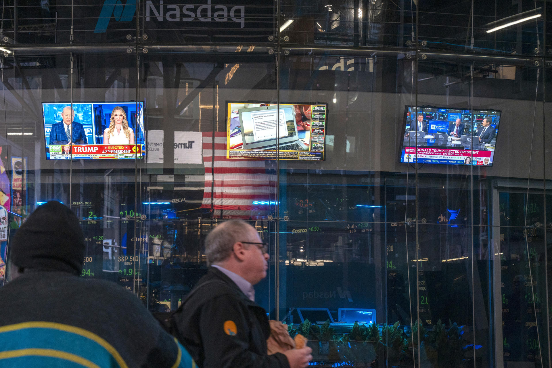 Un hombre camina frente a unos monitores de televisión, encendidos con reportes sobre las elecciones presidenciales, este miércoles en el edificio de Nasdaq en Nueva York (EE.UU.). EFE/Ángel Colmenares