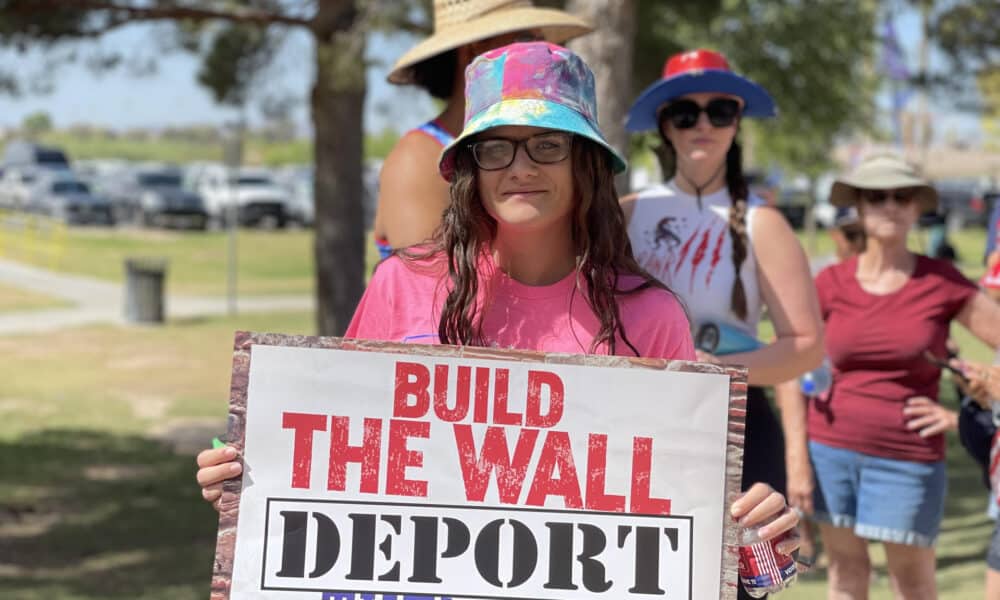 Fotografía de archivo de una mujer con un cartel antimingrantes durante un evento de campaña de Donald Trump. EFE/ Ana Milena Varon