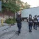 Fotografía de archivo de integrantes de la Policía de Haití pasando frente a los restos de un pandillero incinerado este martes, en una calle de Puerto Príncipe (Haití). EFE/ Johnson Sabin