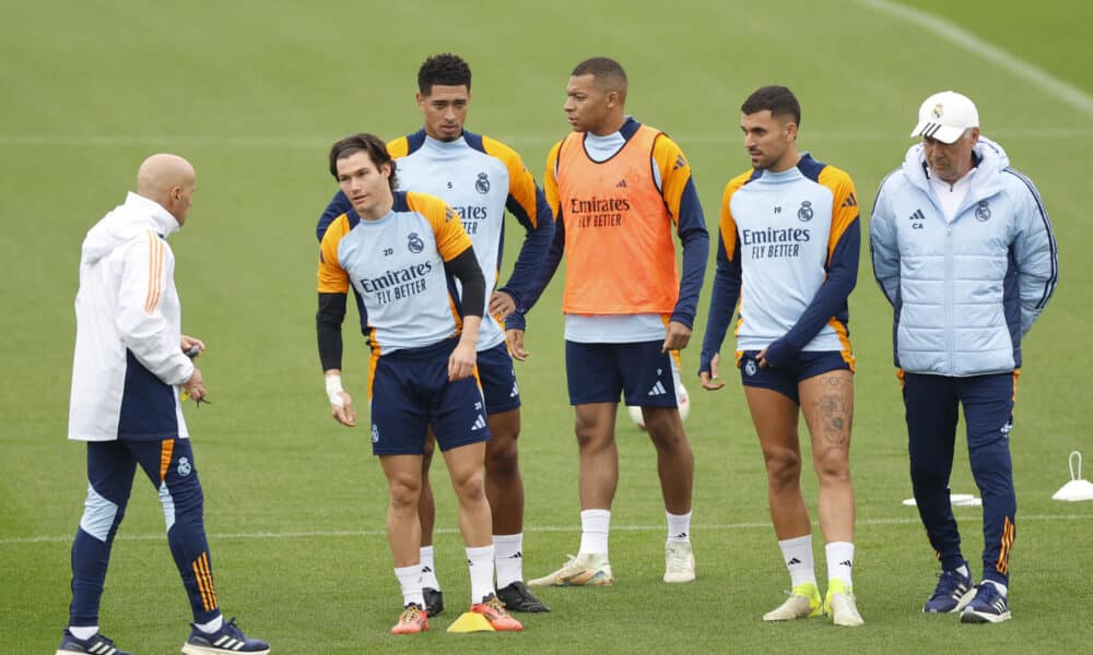 -El entrenador italiano del Real Madrid Carlo Ancelotti (d), el delantero brasileño francés Kylian Mbappé (3d), y el centrocampista ingés Jude Bellingham (3i), este viernes durante el entrenamiento en la Ciudad Deportiva de Valdebebas.-EFE/ Mariscal