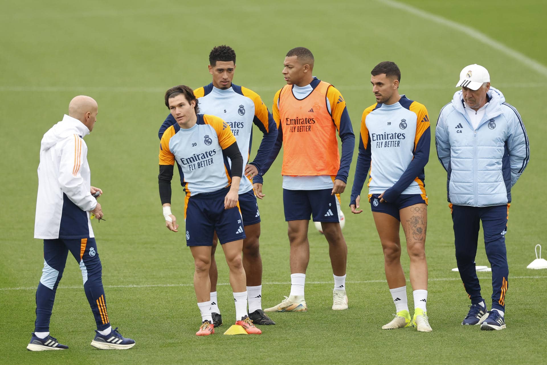 -El entrenador italiano del Real Madrid Carlo Ancelotti (d), el delantero brasileño francés Kylian Mbappé (3d), y el centrocampista ingés Jude Bellingham (3i), este viernes durante el entrenamiento en la Ciudad Deportiva de Valdebebas.-EFE/ Mariscal