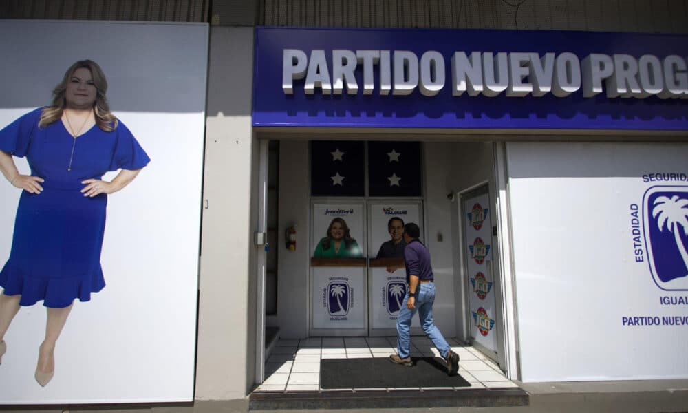 Fotografía del 25 de octubre de 2024 de un hombre entrando a la sede del Partido Nuevo Progresista (PNP), precedido por la foto de la candidata a gobernación, Jenniffer González, en San Juan (Puerto Rico). EFE/ Thais Llorca