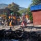 Personas pasan frente a los restos de una hoguera donde incineraron a un pandillero este martes, en una calle de Puerto Príncipe (Haití). EFE/ Johnson Sabin