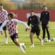 El entrenador del Girona FC, Míchel Sánchez (c), junto a varios de sus jugadores durante el entrenamiento en la Girona Football Academy para preparar el partido de la 5ª jornada de la Liga de Campeones que mañana disputarán ante el Sturm Graz austríaco. EFE/David Borrat.