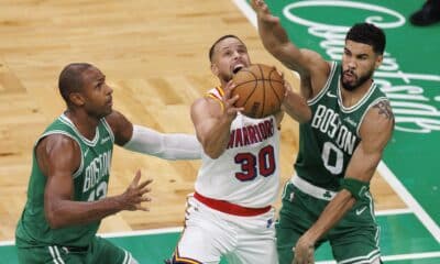 El escolta de los Golden State Warriors Stephen Curry (C) intenta anotar obstaculizado por el pívot de los Boston Celtics, Al Horford (I), y el ala-pívot Jayson Tatum (D) durante el partido de baloncesto de la NBA entre los Boston Celtics y los Golden State Warriors en Boston, Massachusetts. EFE/EPA/CJ GUNTHER SHUTTERSTOCK OUT