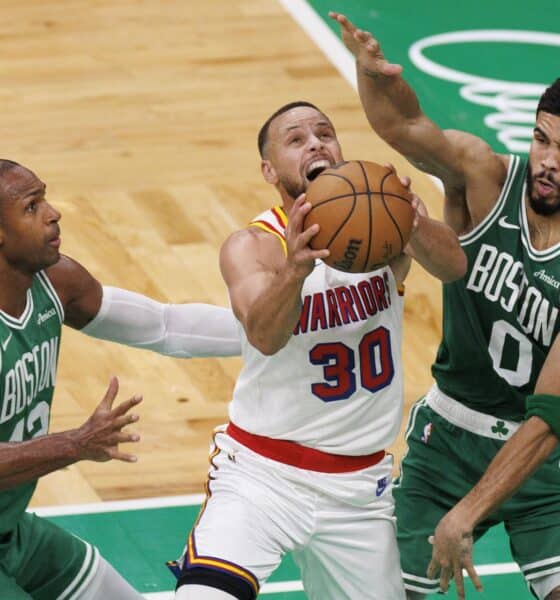 El escolta de los Golden State Warriors Stephen Curry (C) intenta anotar obstaculizado por el pívot de los Boston Celtics, Al Horford (I), y el ala-pívot Jayson Tatum (D) durante el partido de baloncesto de la NBA entre los Boston Celtics y los Golden State Warriors en Boston, Massachusetts. EFE/EPA/CJ GUNTHER SHUTTERSTOCK OUT