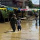 Fotografía cedida por el Ejército de Colombia que muestra a un solado acompañando a un joven por una calle inundada, en Alto Baudó (Colombia). EFE/Ejército de Colombia