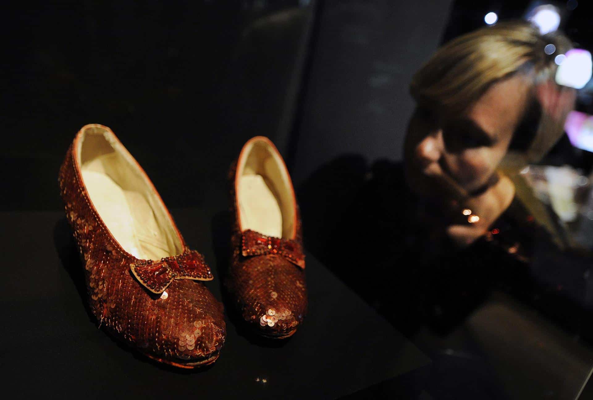 Una empleada del Museo Victoria y Albert observa los zapatos que usó la actriz Judy Garland en 1939 para la película "El Mago de Oz", en la exposición "Vestiario de Hollywood" en Londres, Reino Unido, hoy miércoles 17 de octubre de 2012. 
 EFE/Andy Rain