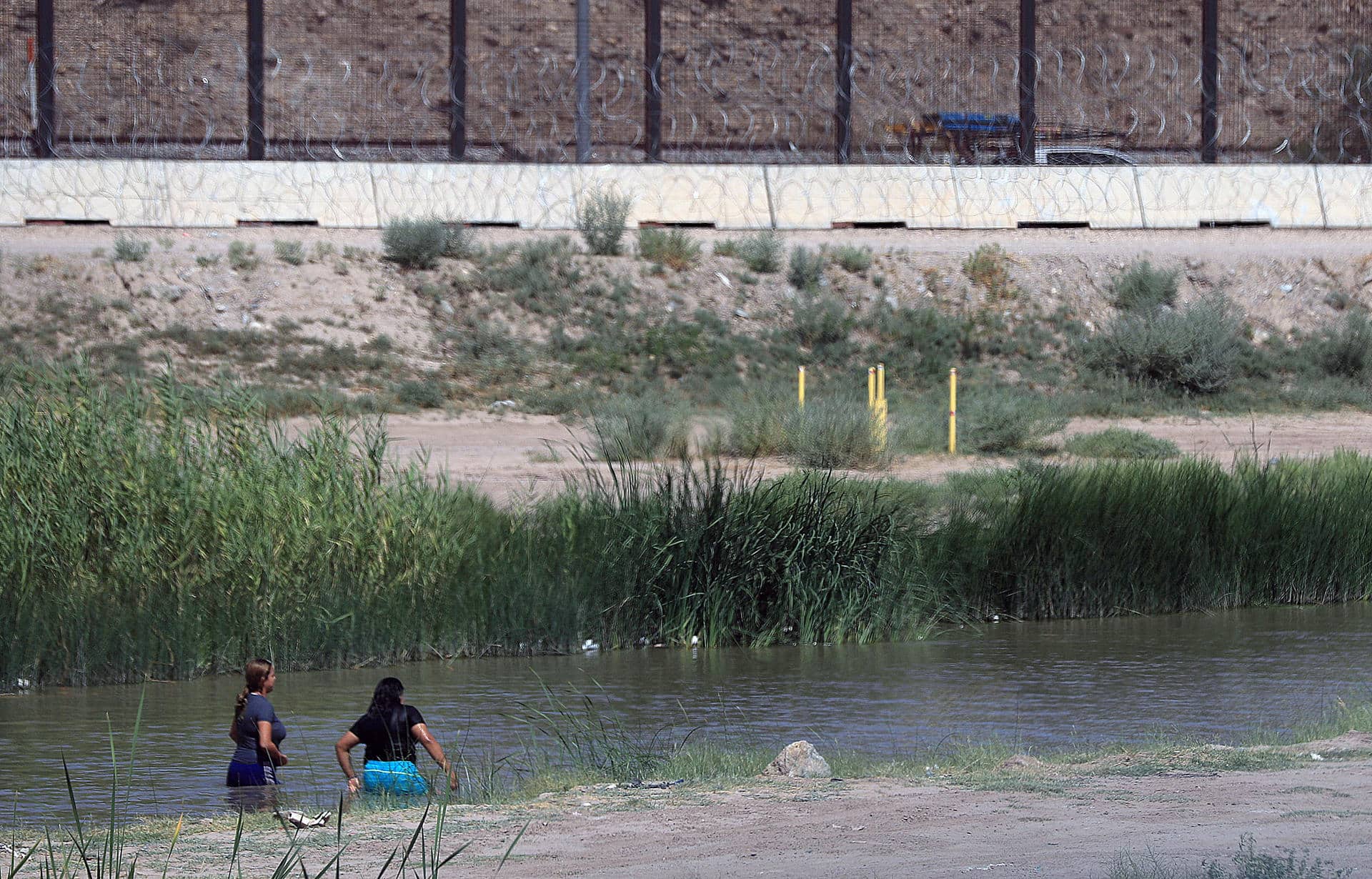 Fotografía de archivo en donde se ven dos mujeres migrantes mientras cruzan el río Bravo (río Grande), frontera natural entre Estados Unidos y México. EFE/Luis Torres