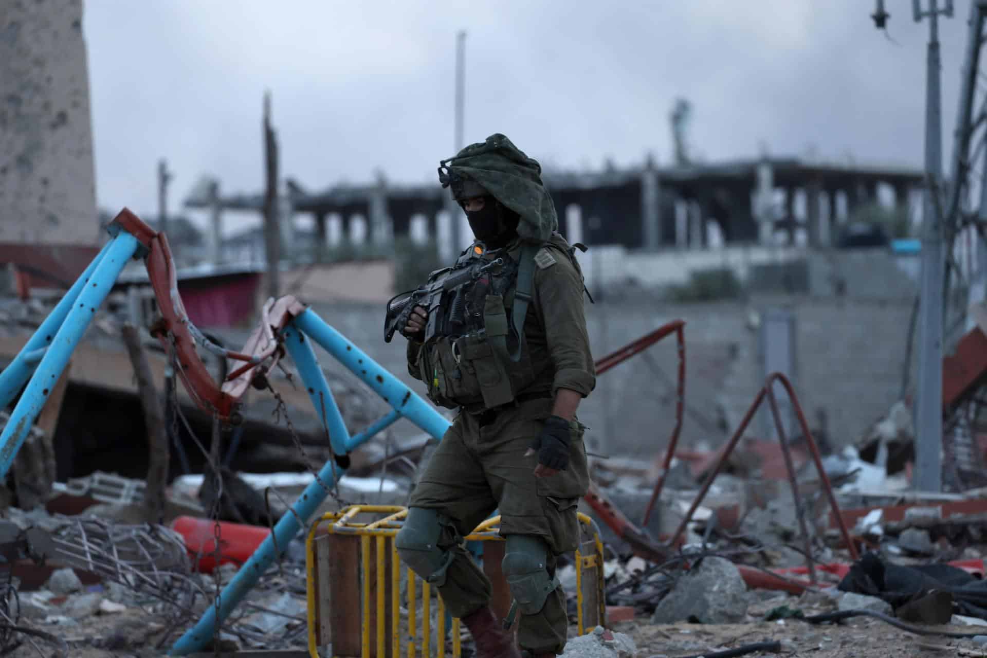 Un soldado israelí camina entre restos de edificios en la ciudad de Beit Lahia. EFE/EPA/ATEF SAFADI