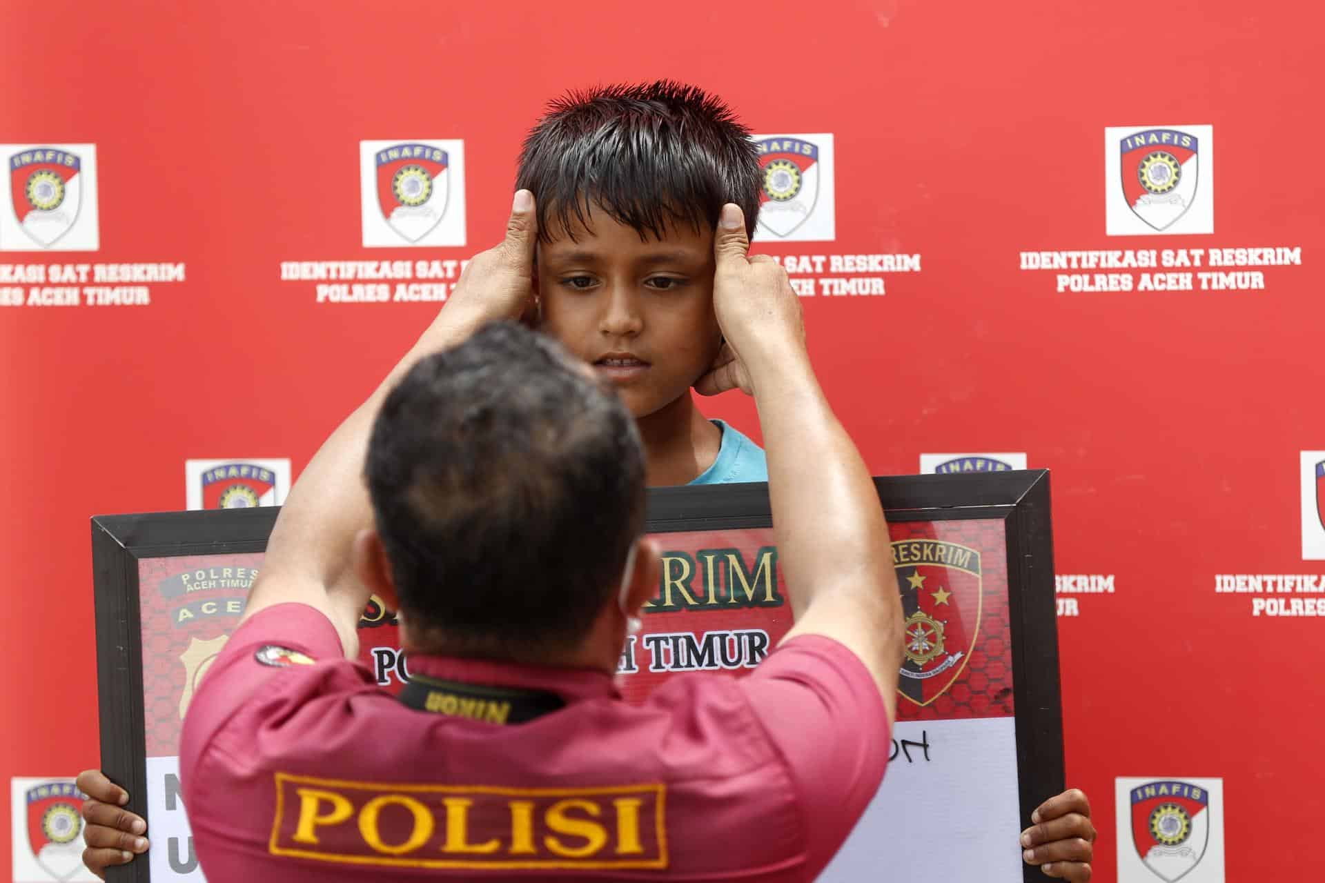 Un policía realiza este viernes labores de identificación de un niño rohinyá en la aldea de Seuneubok Rawang, en la provincia indonesia de Aceh. El niño llegó la víspera en un barco con 96 rohinyás, incluidas seis jóvenes que fallecieron en la travesía. EFE/EPA/HOTLI SIMANJUNTAK