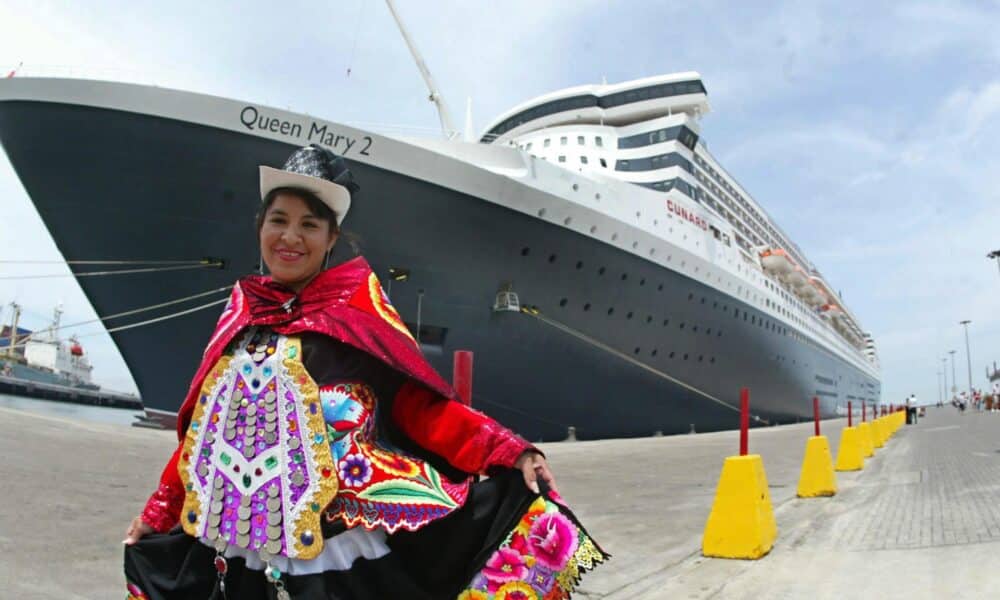 Fotografía de archivo que muestra a una vendedora de souvenirs posando al frente de un crucero transatlántico en el puerto del Callao (Perú). EFE/Stringer