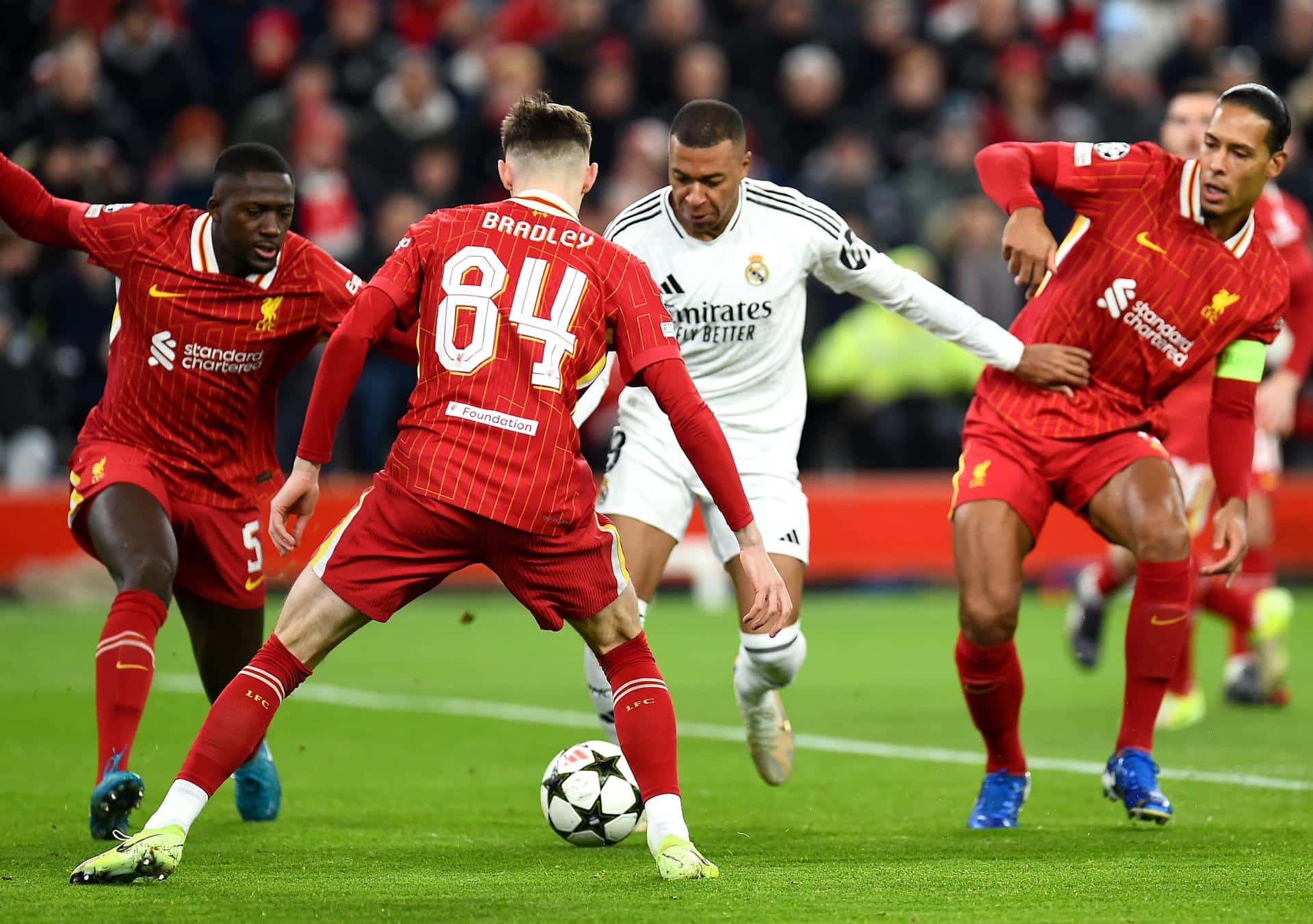 Virgil van Dijk (D), Ibrahima Konate (I) y Conor Bradley frenan a Kylian Mbappe (C) en anfield, Liverpool, Reino Unido. EFE/EPA/PETER POWELL