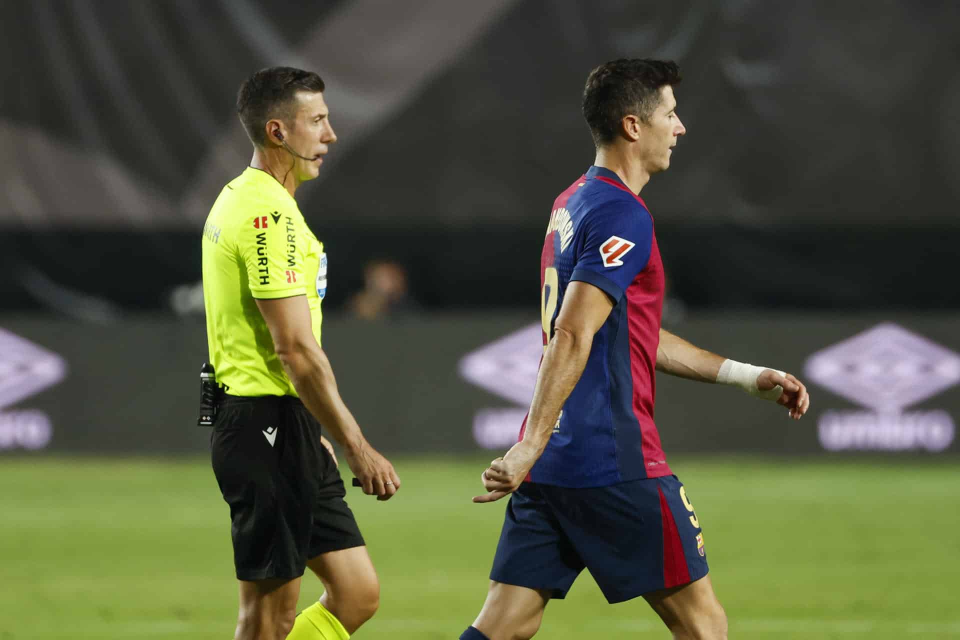 El árbitro Soto Grado (i) y Robert Lewandowski (d), del Barcelona,e una foto de archivo. EFE/Mariscal