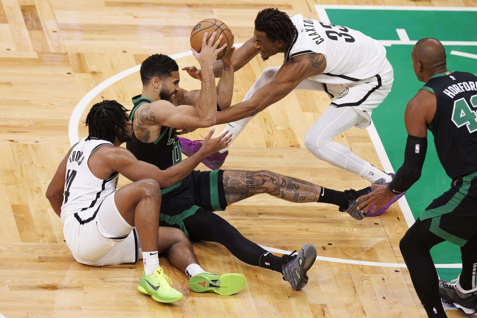 Jayson Tatum, de los Celtics, sostiene el balón ante la marca de Cam Thomas (i) y Nic Claxton, de los Nets, ante la mirada expectante de Al Horford (d) durante el partido que se jugó en Boston. EFE/EPA/CJ GUNTHER