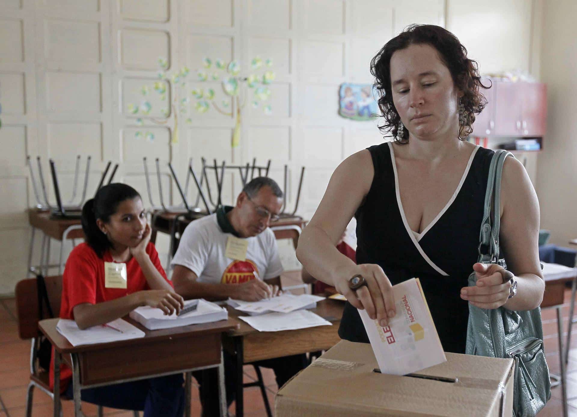 Fotografía de archivo en donde se ve a una mujer que deposita su voto en una urna en San José (Costa Rica). EFE/Jeffrey Arguedas