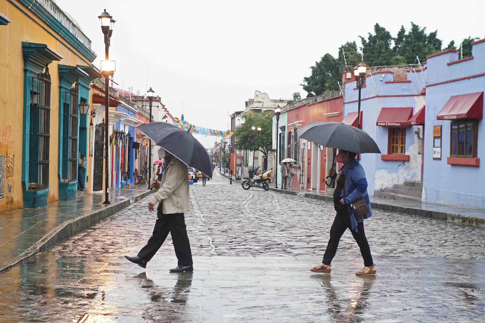 Dos personas se protegen de la lluvia en el estado de Oaxaca (México). Archivo. EFE/Daniel Ricardez