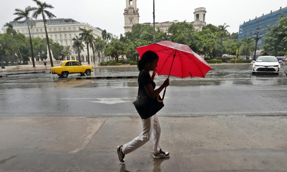 Fotografía de archivo en la que una mujer camina bajo la lluvia en La Habana (Cuba). EFE/ Ernesto Mastrascusa