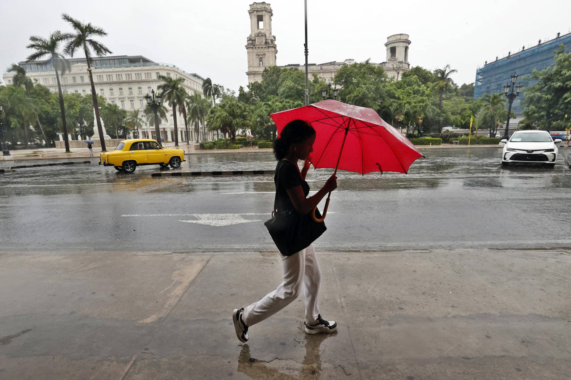 Fotografía de archivo en la que una mujer camina bajo la lluvia en La Habana (Cuba). EFE/ Ernesto Mastrascusa