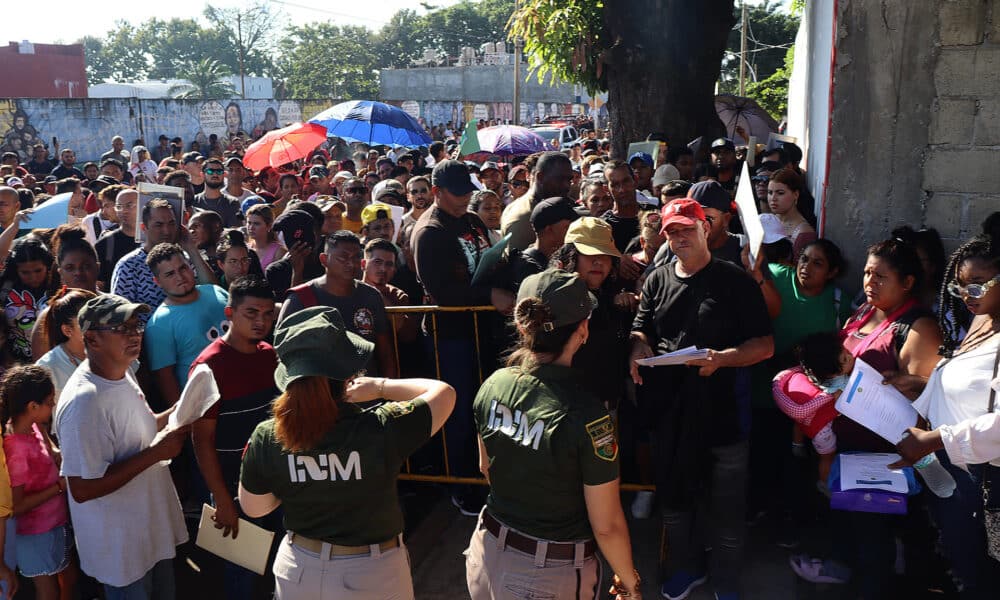 Personal del Instituto Nacional de Migración (INM) hablan con migrantes que esperan resolver su situación migratoria, el 31 de octubre de 2024, en la ciudad de Tapachula (México). EFE/Juan Manuel Blanco