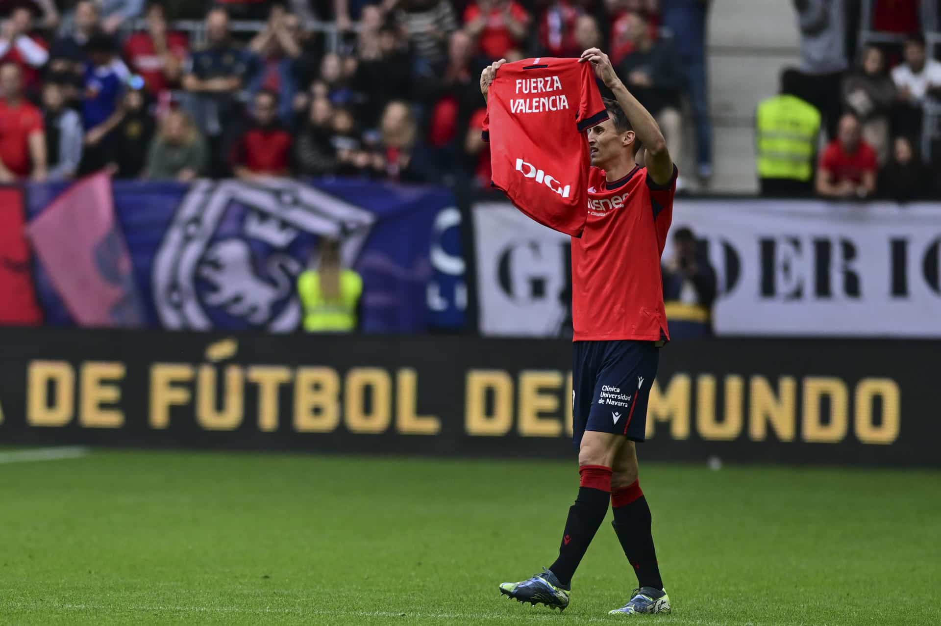 El jugador croata del Osasuna Ante Budimir muestra una camiseta con el mensaje 'Fuerza Valencia' antes del inicio del partido de la 12ª jornada de LaLiga contra el Osasuna en el Estadio de El Sadar, en Pamplona, este sábado. EFE/ Iñaki Porto