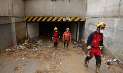 Efectivos del cuerpo de bomberos durante las labores del limpieza y búsqueda de posibles fallecidos en un aparcamiento subterráneo de Jaume I en Sedaví, al lado del Ayuntamiento, este lunes. EFE/Ana Escobar