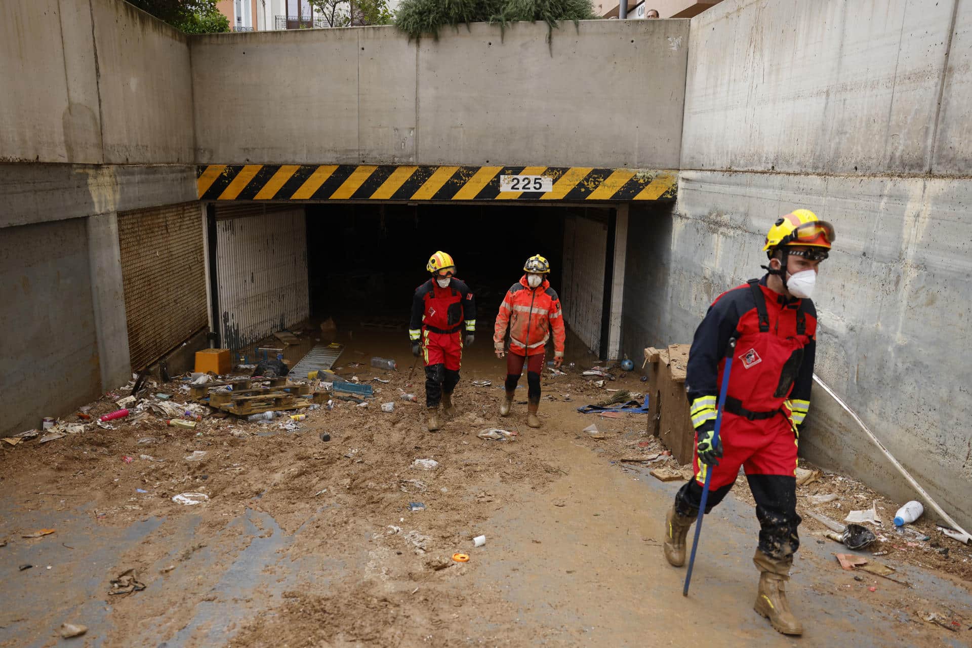 Efectivos del cuerpo de bomberos durante las labores del limpieza y búsqueda de posibles fallecidos en un aparcamiento subterráneo de Jaume I en Sedaví, al lado del Ayuntamiento, este lunes. EFE/Ana Escobar