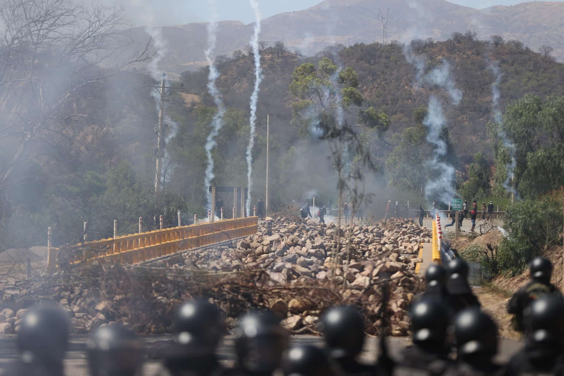 Simpatizantes del expresidente de Bolivia, Evo Morales (2006-2019), se enfrentan con integrantes de la Policía Boliviana este viernes, en Parotani (Bolivia). Un gran contingente de policías y militares bolivianos desbloquean las carreteras tomadas por los seguidores del expresidente Evo Morales (2006-2019) desde hace 19 días, medida que ejercen en defensa de su líder ante una posible orden de captura en su contra por un caso de trata de personas y estupro. EFE/ Luis Gandarillas