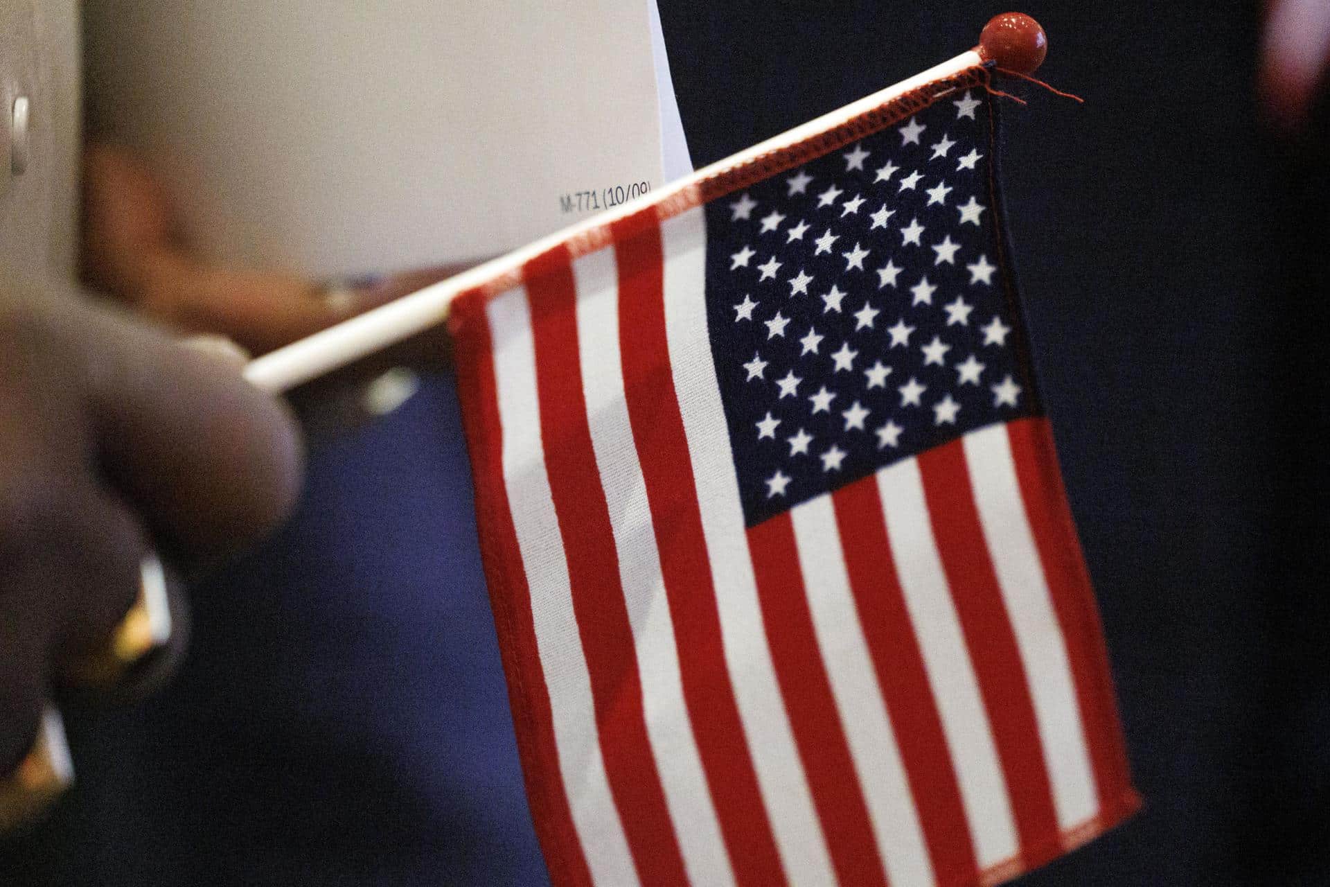 Una persona sostiene una pequeña bandera de Estados Unidos. EFE/EPA/CJ GUNTHER