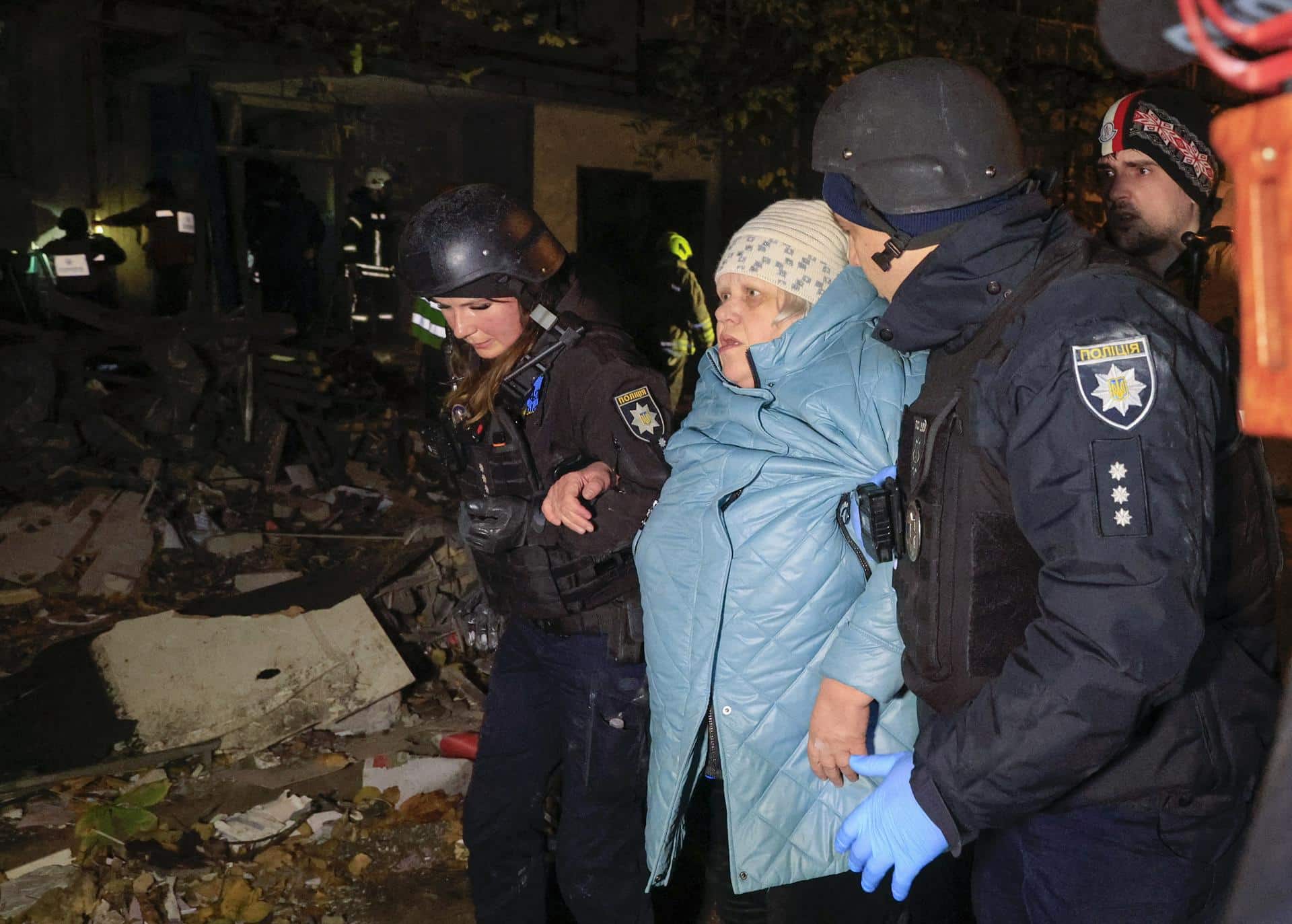 Los equipos de rescate ayudan a una mujer tras un ataque con bomba planeadora contra un edificio residencial en Járkov, Ucrania, el 8 de noviembre de 2024. EFE/EPA/SERGEY KOZLOV