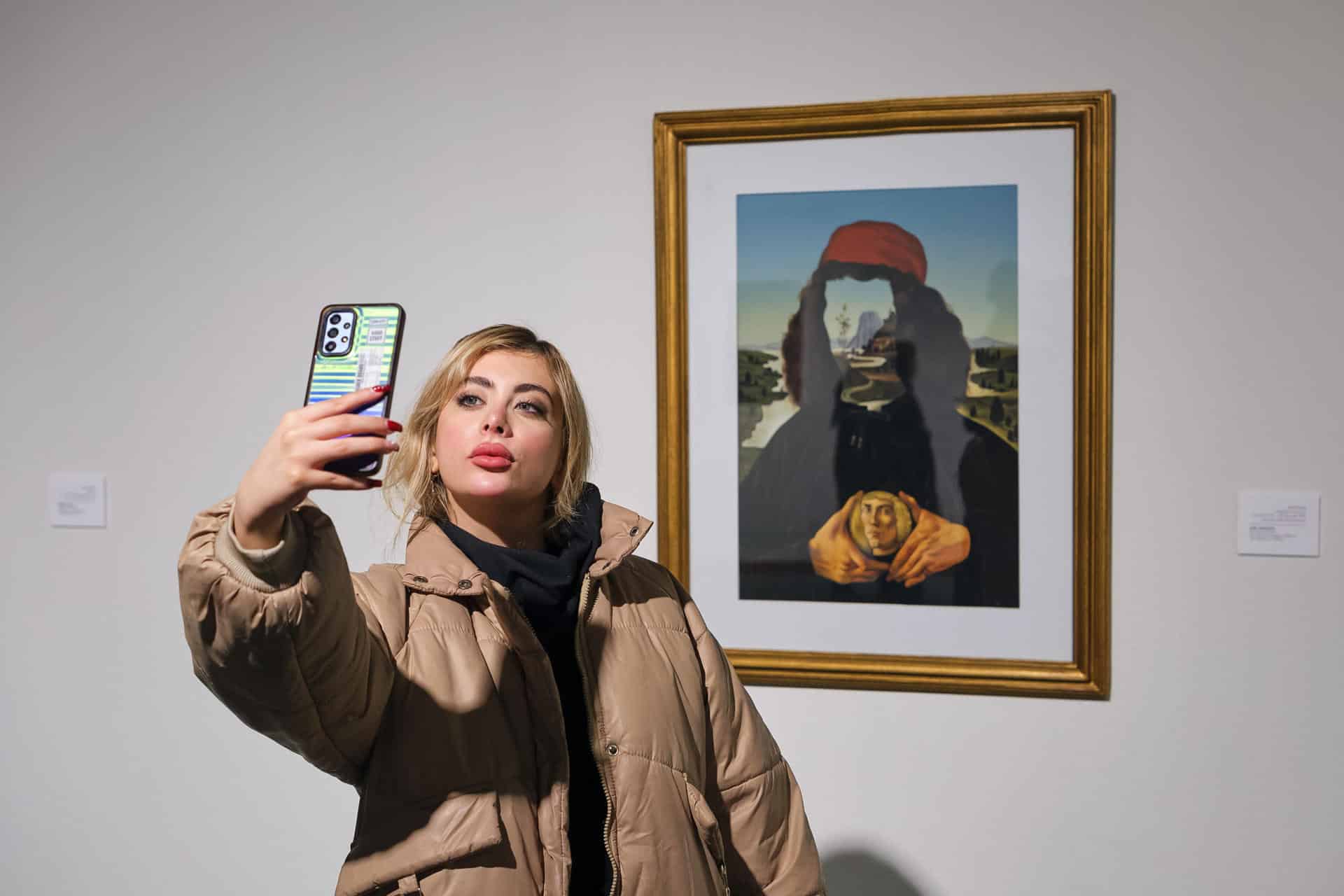 Una joven se hace un selfie Picasso, ante el cuadro 'Retrato de Boticelli', del pintor Aydin Aghdashloo, en el Museo de Arte Contemporáneo de Teherán. EFE/Jaime León