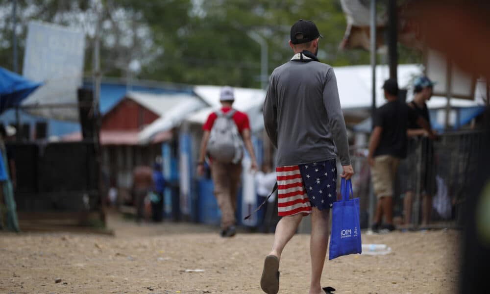 Un migrante camina vistiendo una prenda impresa con la bandera de los Estados Unidos en la Estación Temporal de Recepción Migratoria (ETRM), en Lajas Blancas, Darién (Panamá). EFE/Bienvenido Velasco