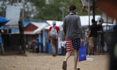 Un migrante camina vistiendo una prenda impresa con la bandera de los Estados Unidos en la Estación Temporal de Recepción Migratoria (ETRM), en Lajas Blancas, Darién (Panamá). EFE/Bienvenido Velasco